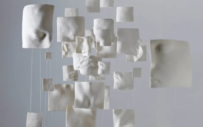 Photo d'une installation de l'exposition « Aux frontières de l'humain », composée des carrés blancs en suspension représentant l'anatomie humaine