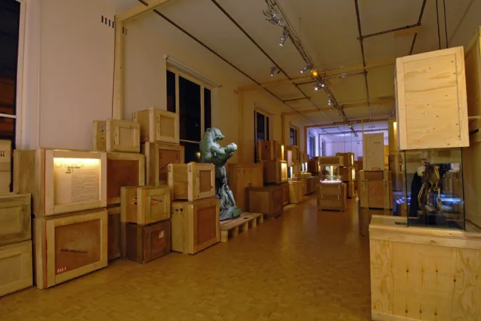 Caisses en bois et statue dans l'exposition « La Saga de l'Homme »